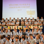Students sitting on stage for Chanukah concert