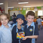 Students holding their lego sukkah