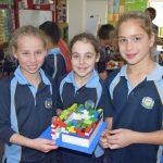 Students holding their lego design