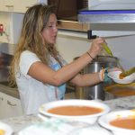 Student serving soup in the kitchen