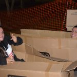 Students sitting in cardboard boxes