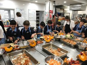 Students chopping pumpkin in the kitchen