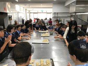 Students rolling dough in the kitchen