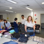 Masada students folding and packing clothes