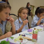 Masada students eating together at Pesach Passion hall