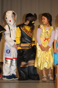 Students dressed in funky costumes standing on stage